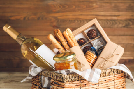 Gift basket with products on wooden background